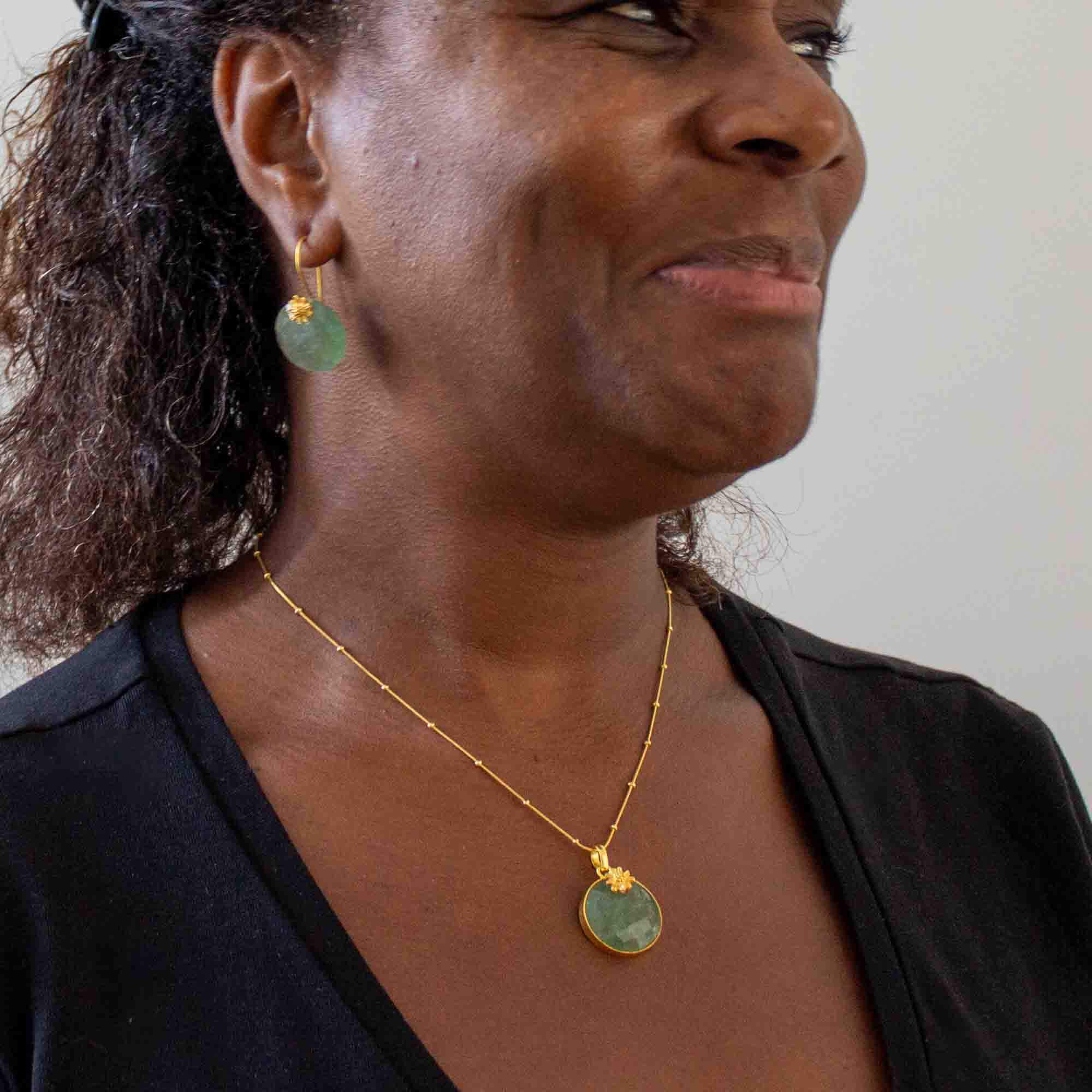 Model wearing Green aventurine round faceted gemstone pendant necklace and earrings with 18k gold vermeil flower detail - Beyond Biasa