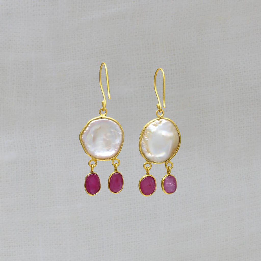 Drop Earrings featuring irregular biwa pearls in a simple 18k gold vermeil setting with two ruby gemstones hanging below and a hook fitting