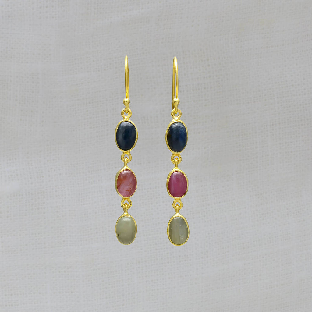 Three stone sapphire drop earrings, featuring oval shaped pink, blue and green sapphire gemstones in a simple gold vermeil setting, with a hook fitting.