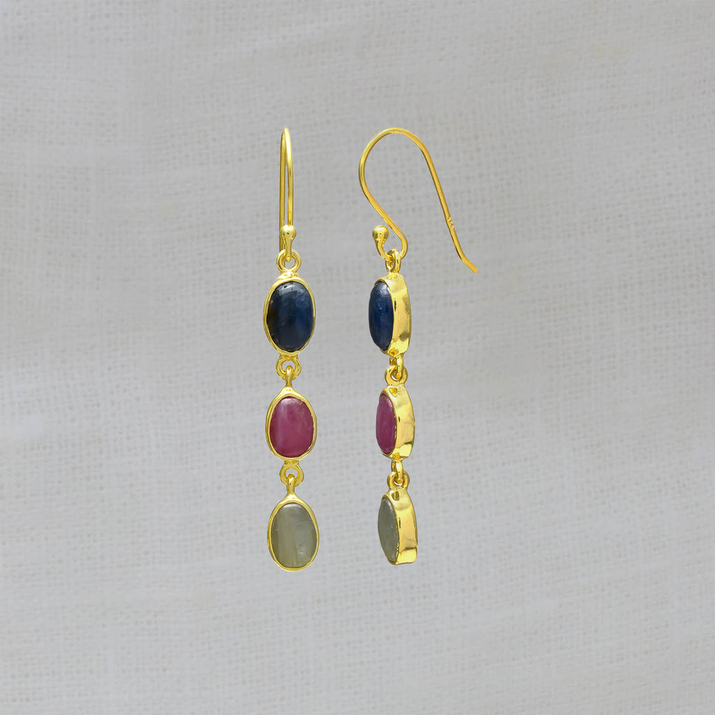 Three stone sapphire drop earrings, featuring oval shaped pink, blue and green sapphire gemstones in a simple gold vermeil setting, with a hook fitting.
