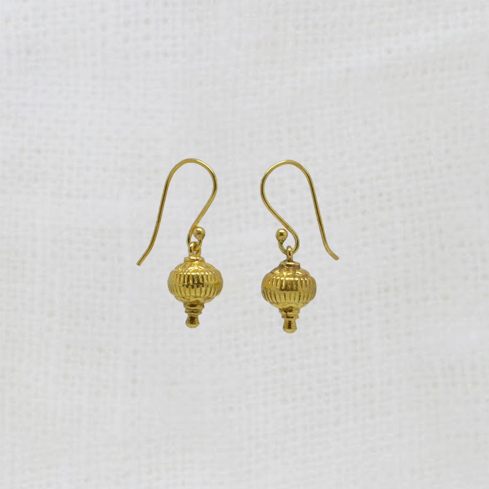 Pair of gold earrings on a light gray background