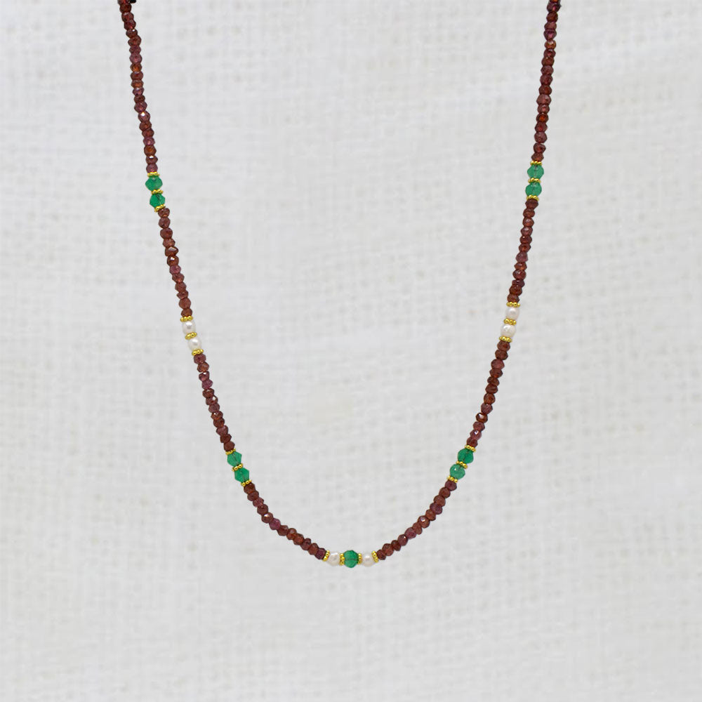 Necklace with red garnet and green onyx beads on a white background