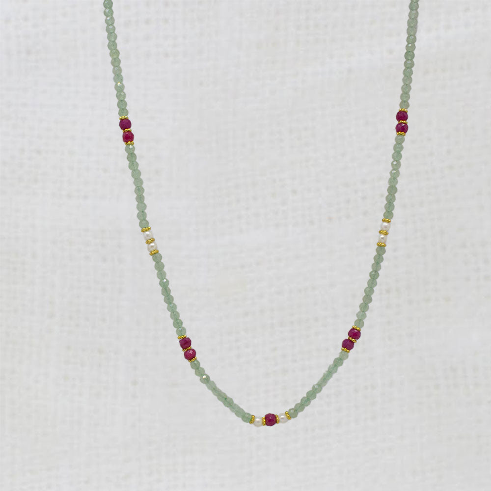 Necklace with green aventurine beads and red ruby and gold accents on a white background