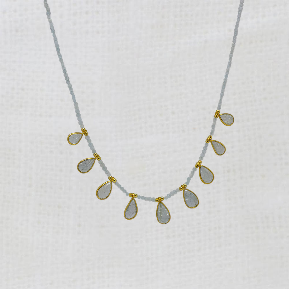 aquamarine Necklace with teardrop-shaped carved pendants on a white background