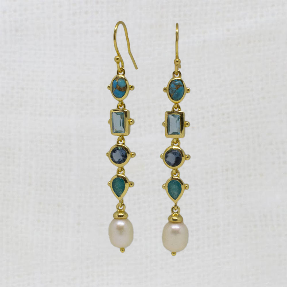 Gold hook dangle earrings with blue gemstones and pearls on a white background