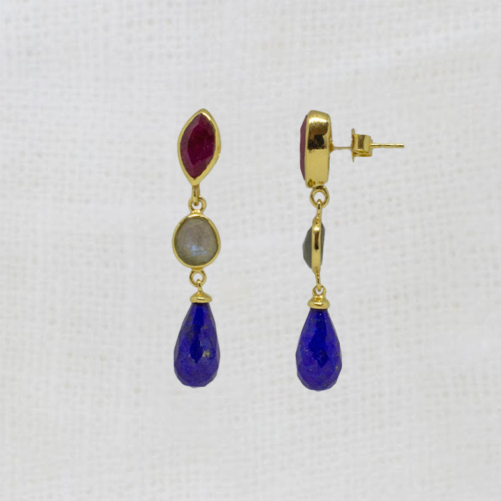 Pair of gold earrings with ruby, labradorite and lapis gemstones on a white background