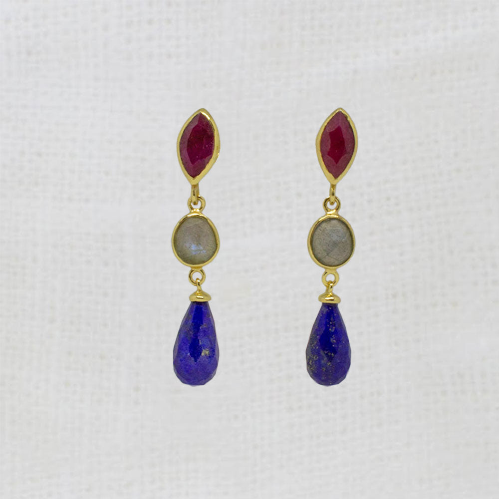 Pair of gold earrings with ruby, labradorite and lapis gemstones on a white background
