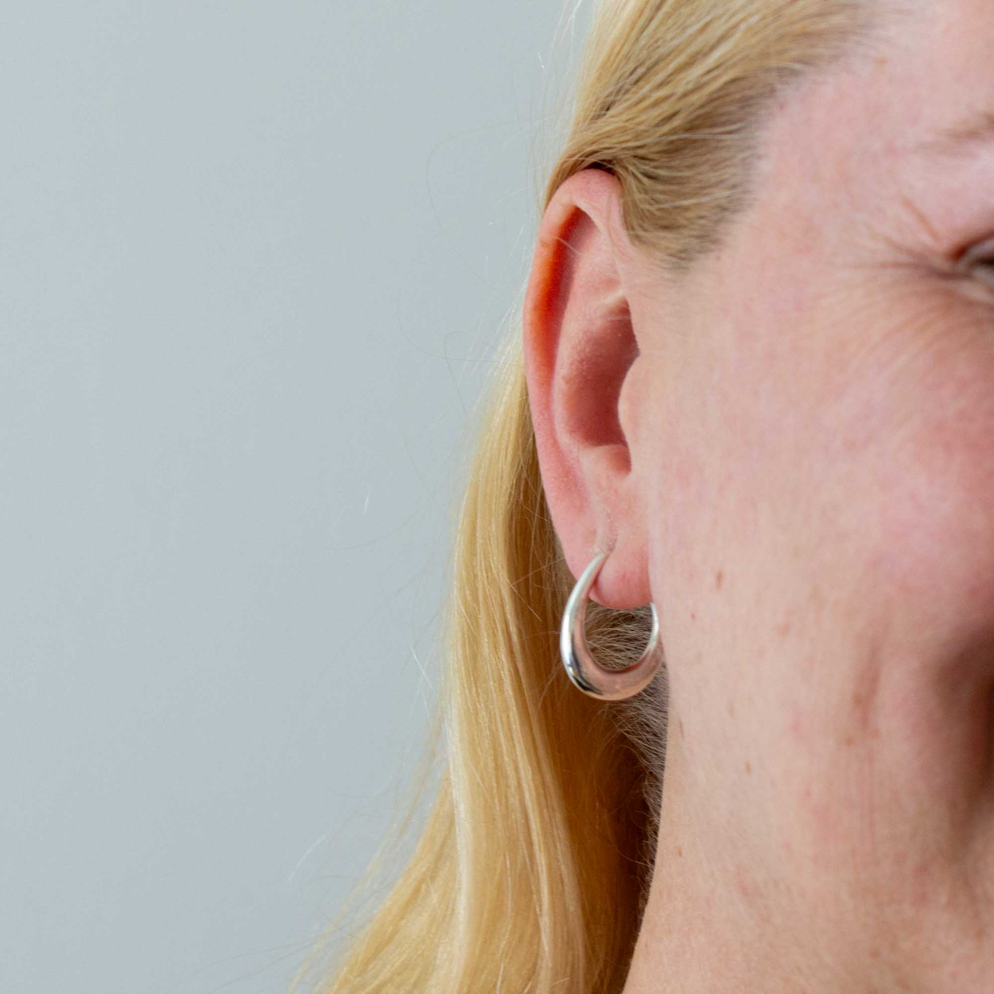 Model wearing Minimal sterling silver tapered hoop earrings with stud fitting | Beyond Biasa