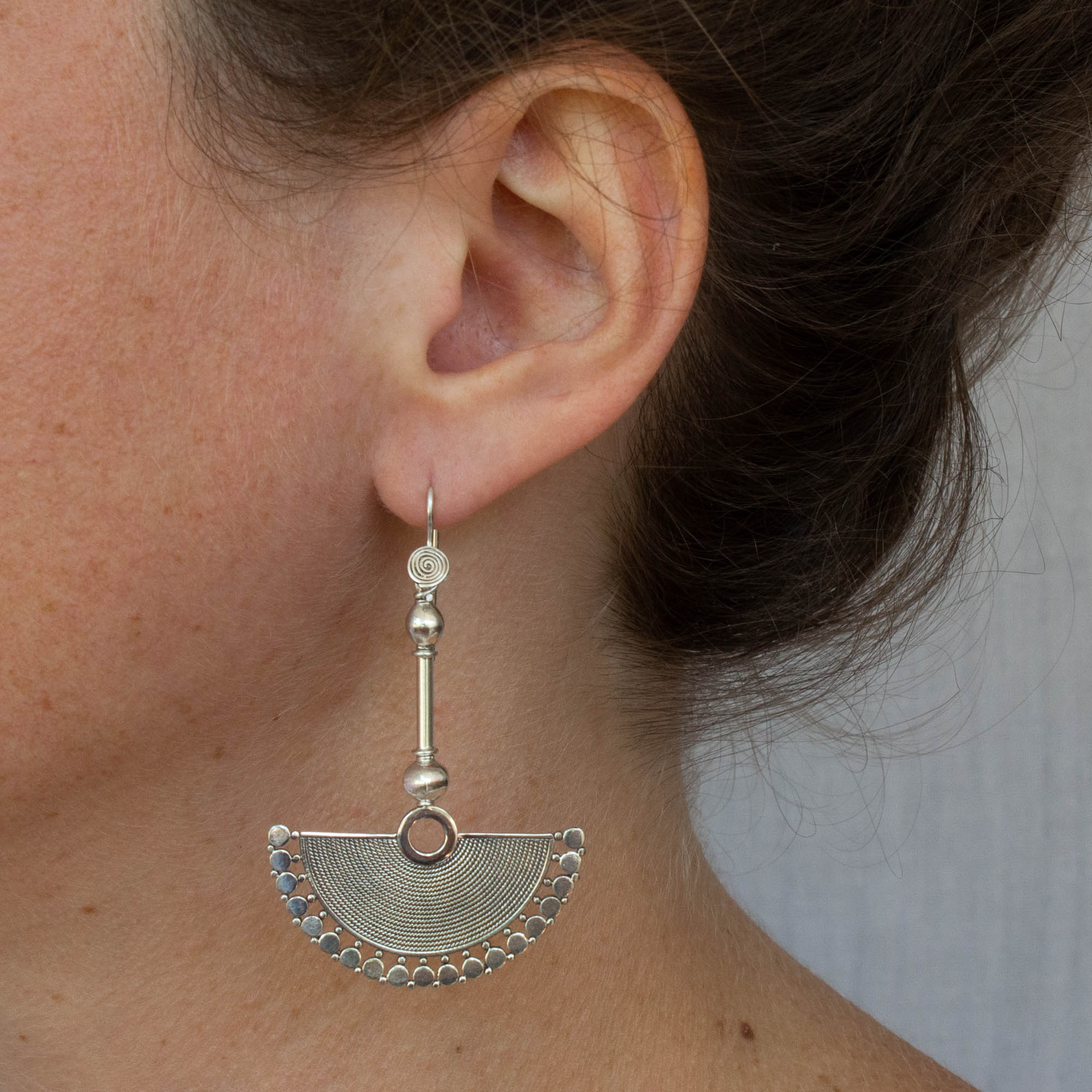 Model wearing Large sterling silver fan shaped drop earrings with oxidised wirework detail and a hook fitting - Beyond Biasa