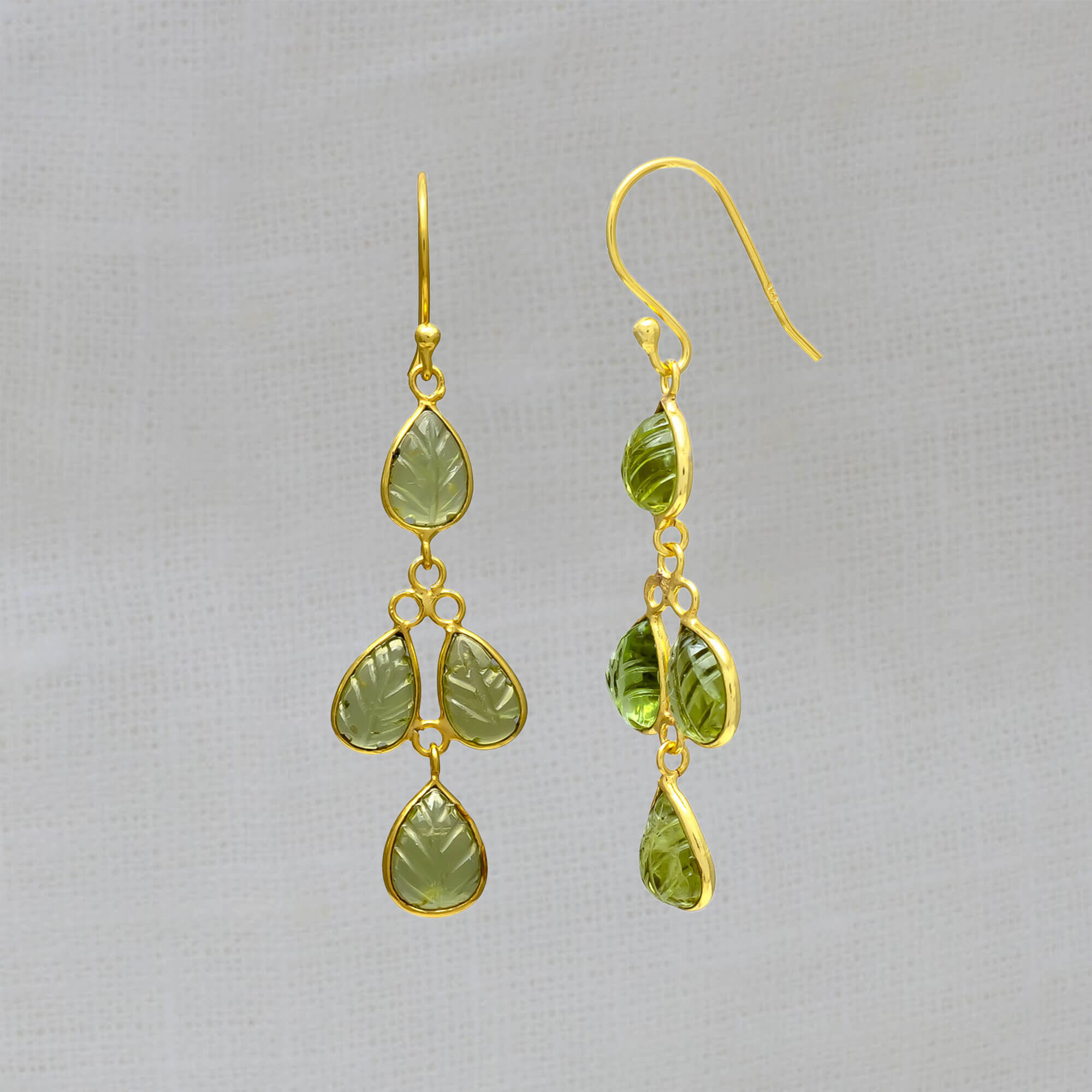 Drop earrings featuring 4 small leaf shaped carved peridot gemstones in a simple 18k gold vermeil setting, with a hook fitting