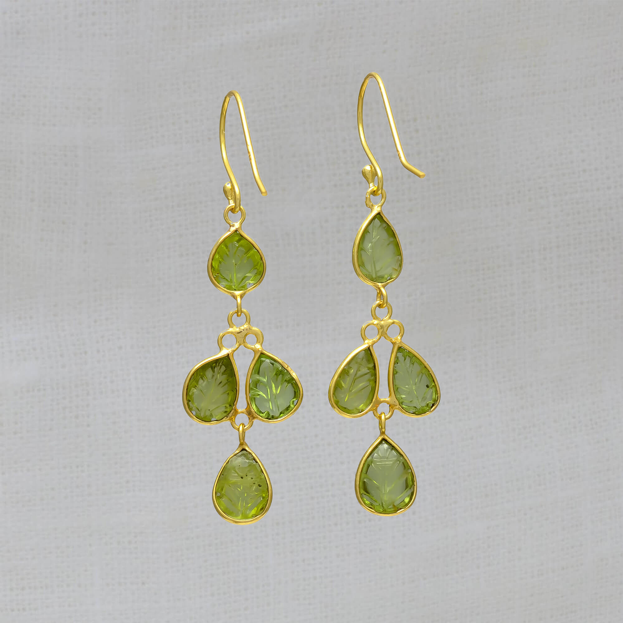Drop earrings featuring 4 small leaf shaped carved peridot gemstones in a simple 18k gold vermeil setting, with a hook fitting