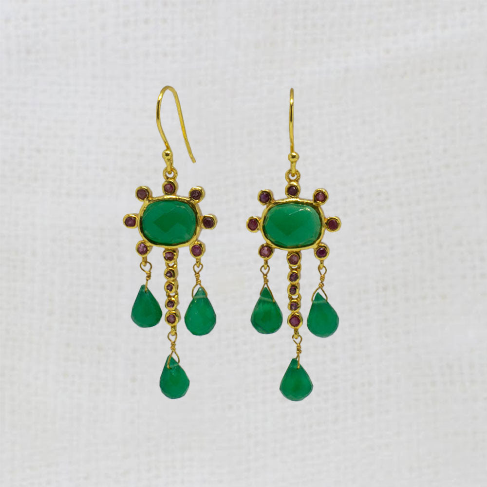 Gold earrings with green onyx and ruby gemstones and red stones on a white background