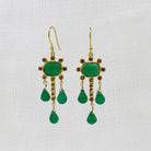 Gold earrings with green onyx and ruby gemstones and red stones on a white background