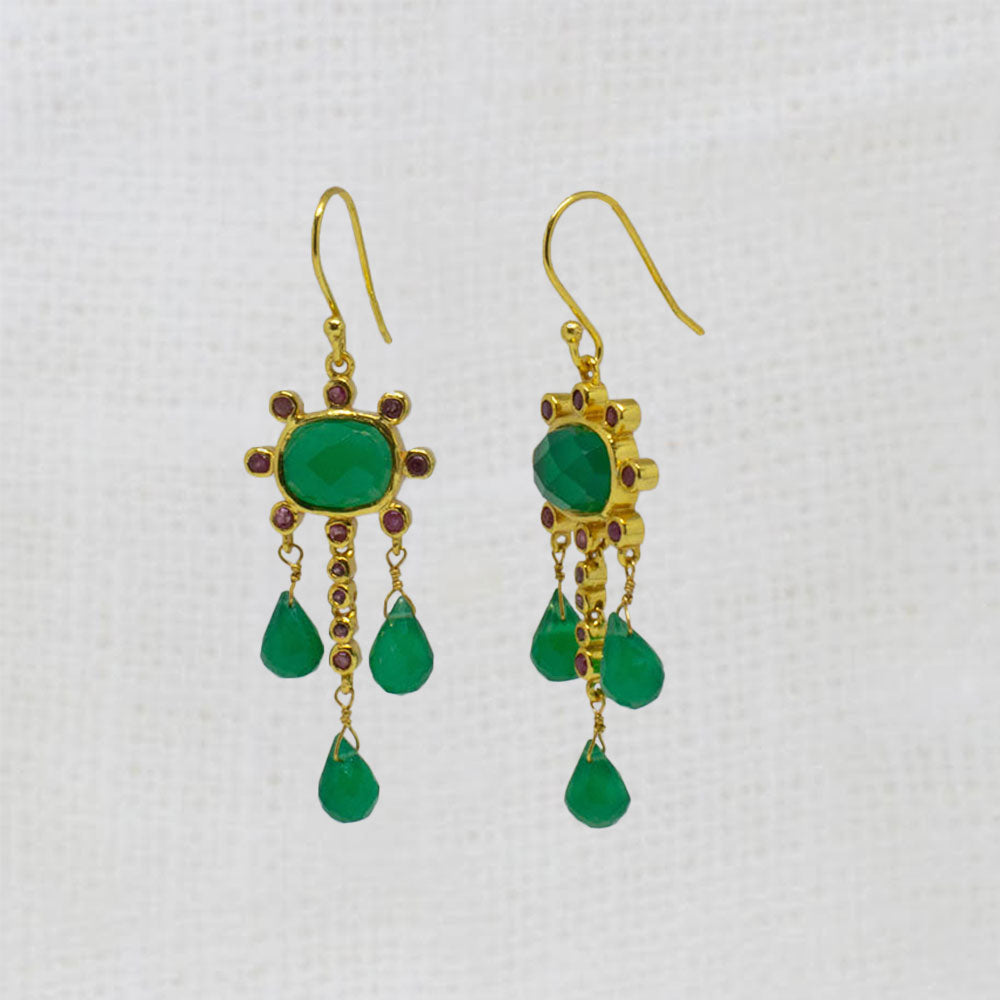 Gold earrings with green onyx and ruby gemstones and red stones on a white background