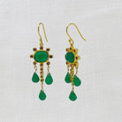 Gold earrings with green onyx and ruby gemstones and red stones on a white background