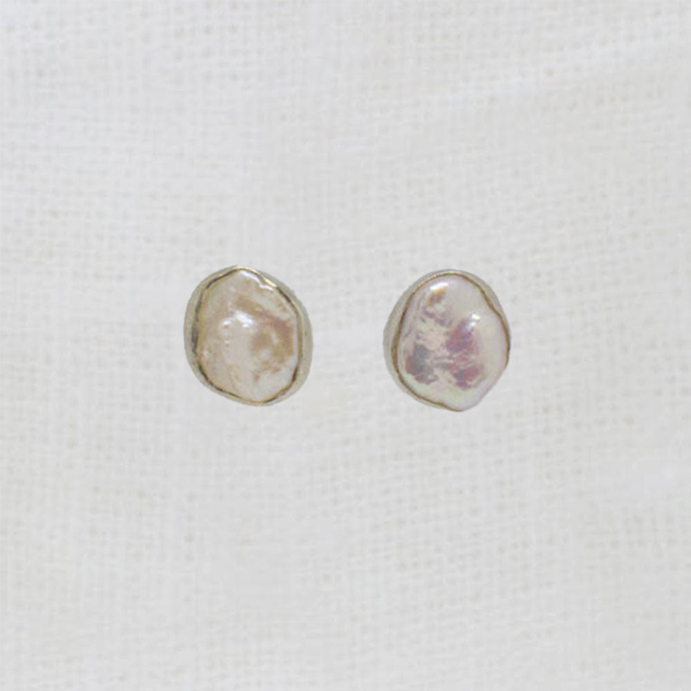 Pair of pearl earrings on a white fabric background
