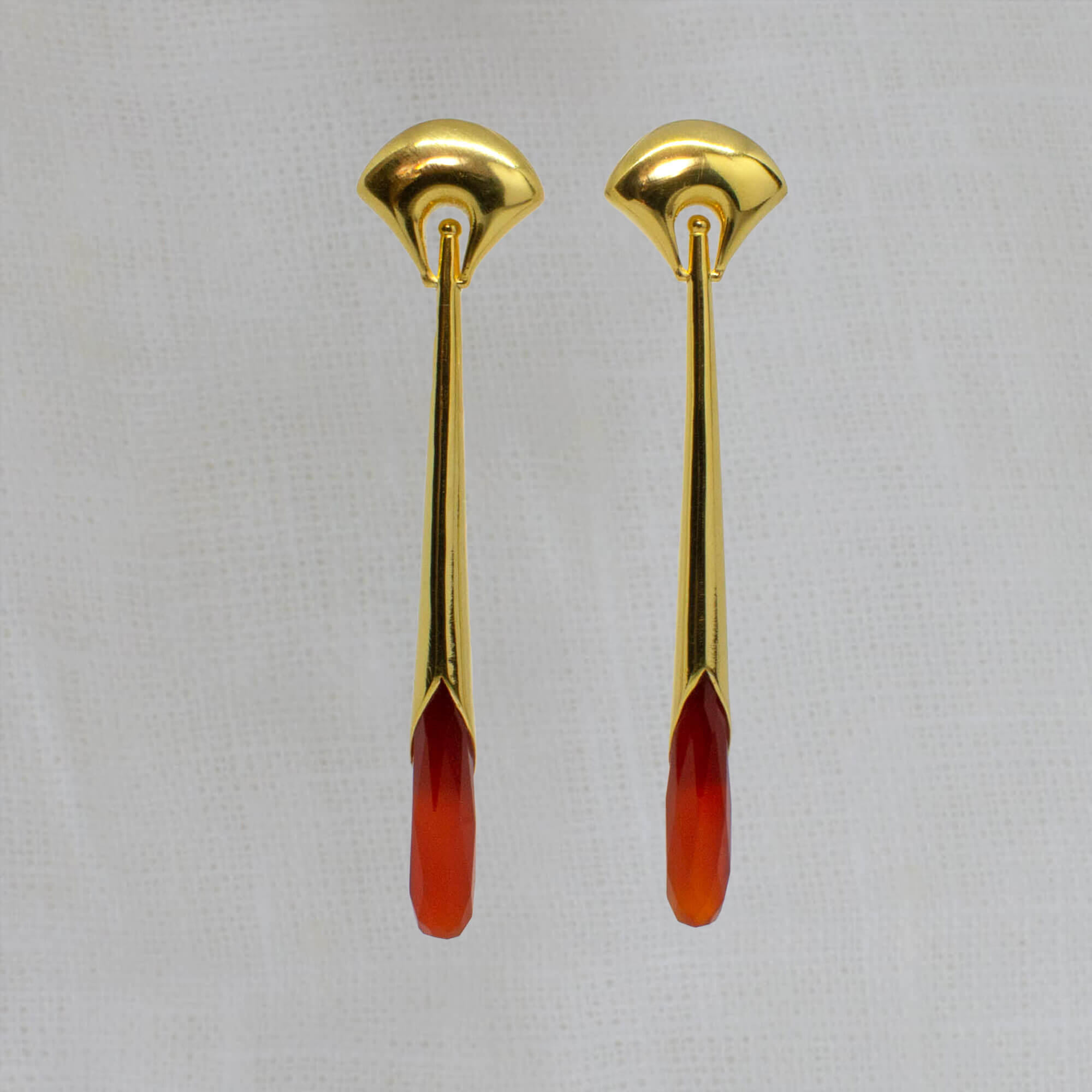 Long statement earrings in 18k gold vermeil with a curved stud and long drop with faceted carnelian gemstone