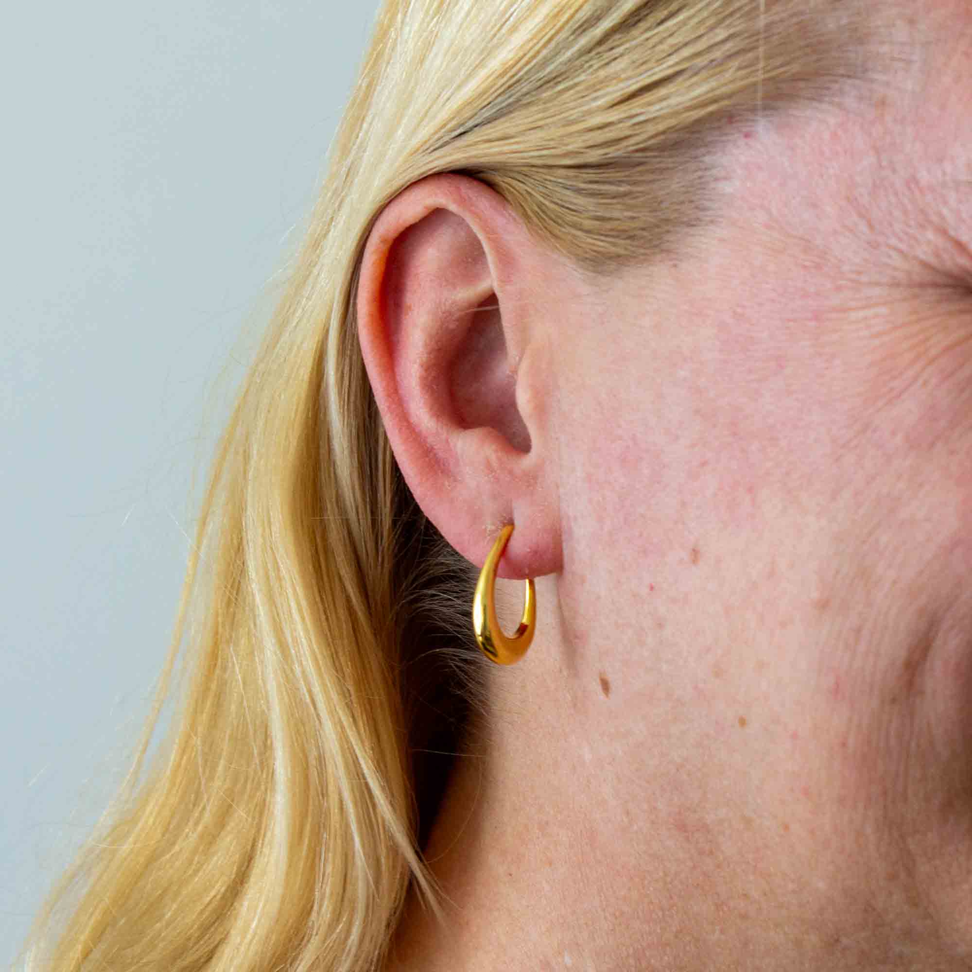 Model wearing Minimal 18k gold vermeil tapered hoop earrings with stud fitting | Beyond Biasa