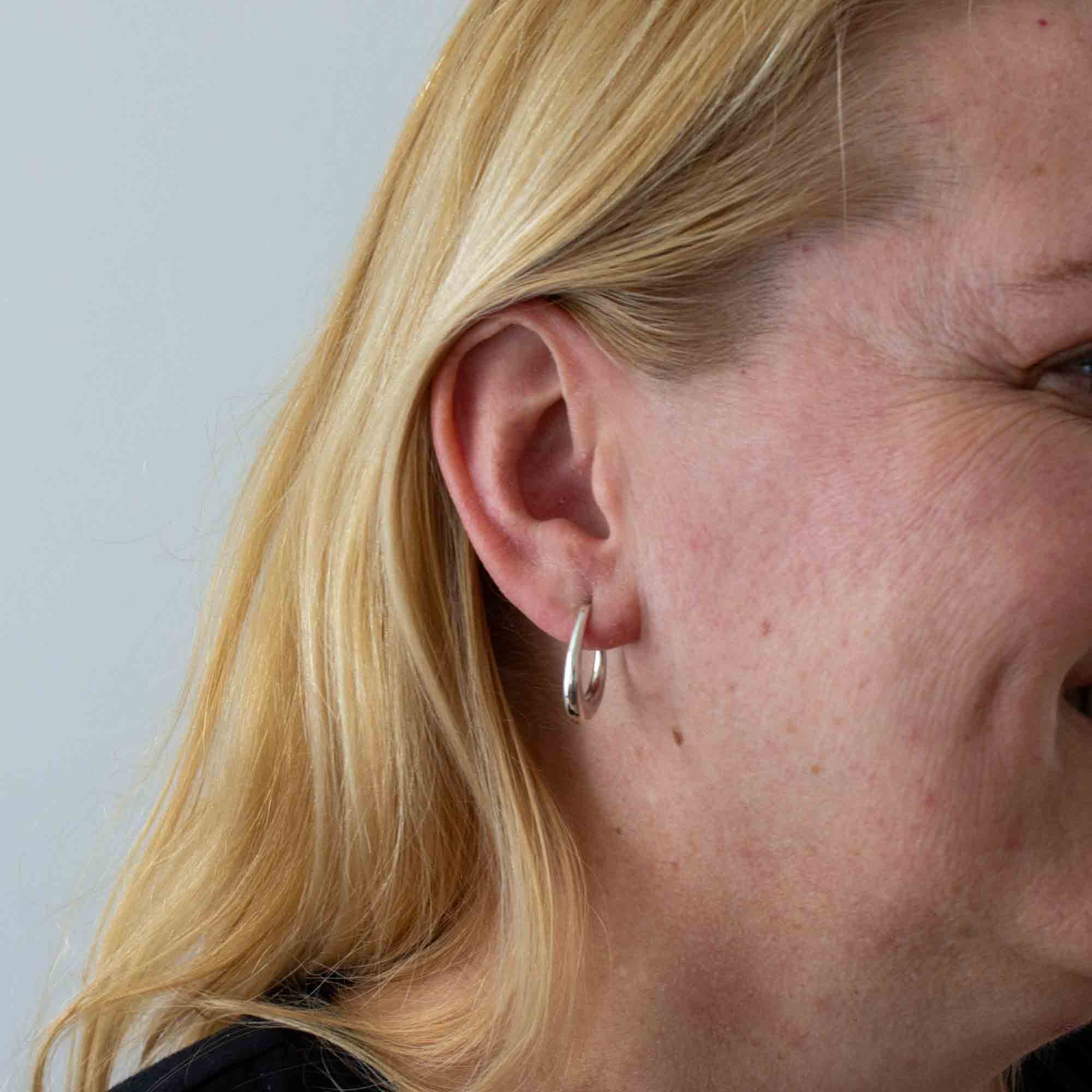 Model wearing Minimal sterling silver tapered hoop earrings with stud fitting | Beyond Biasa