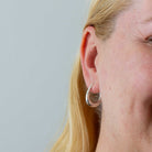 Model wearing Minimal sterling silver tapered hoop earrings with stud fitting | Beyond Biasa