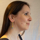 A pair of Art Nouveau-inspired drop earrings with gold vermeil and labradorite, worn by model
