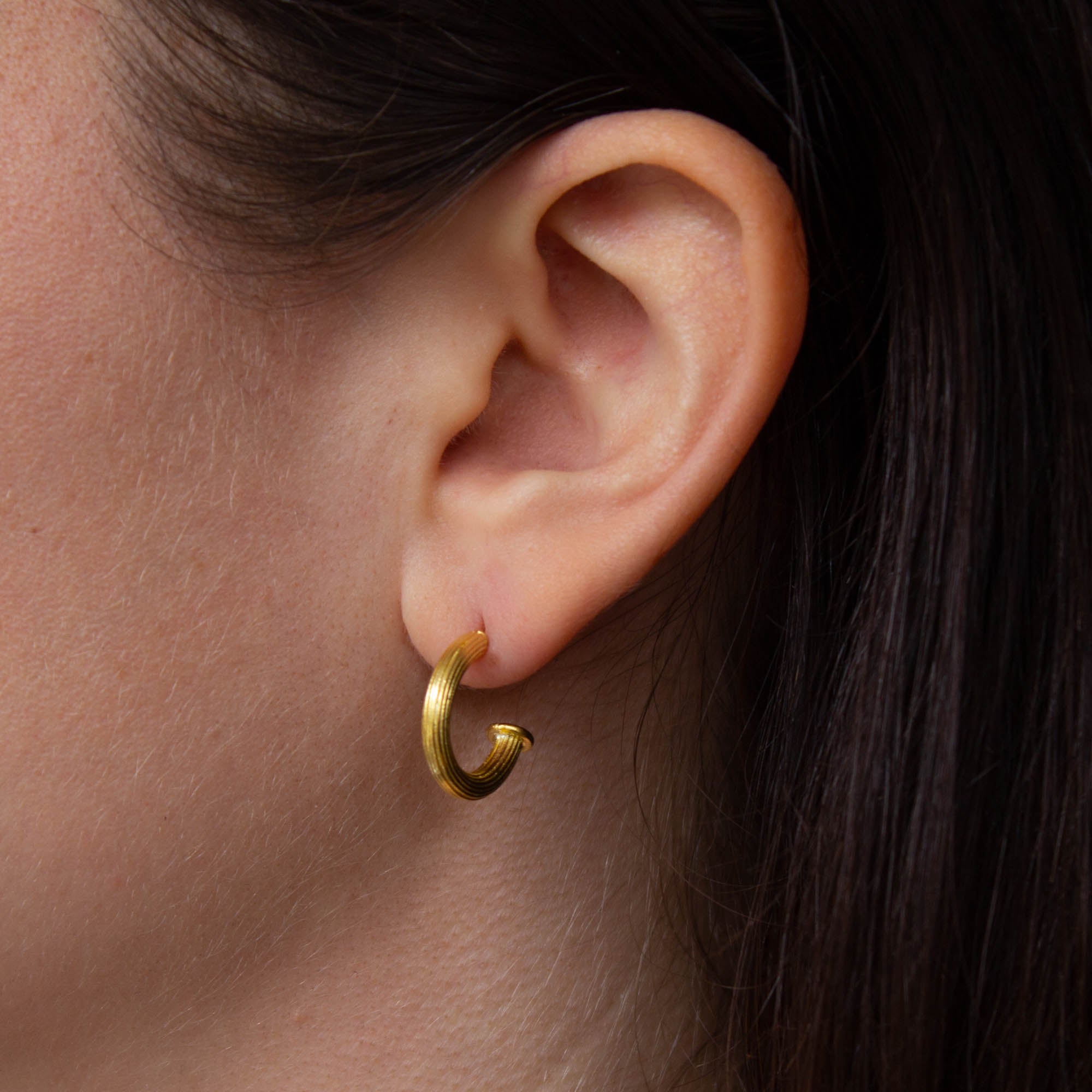 Model wearing 18k gold vermeil ridged textured half hoop earrings with stud fitting | Beyond Biasa