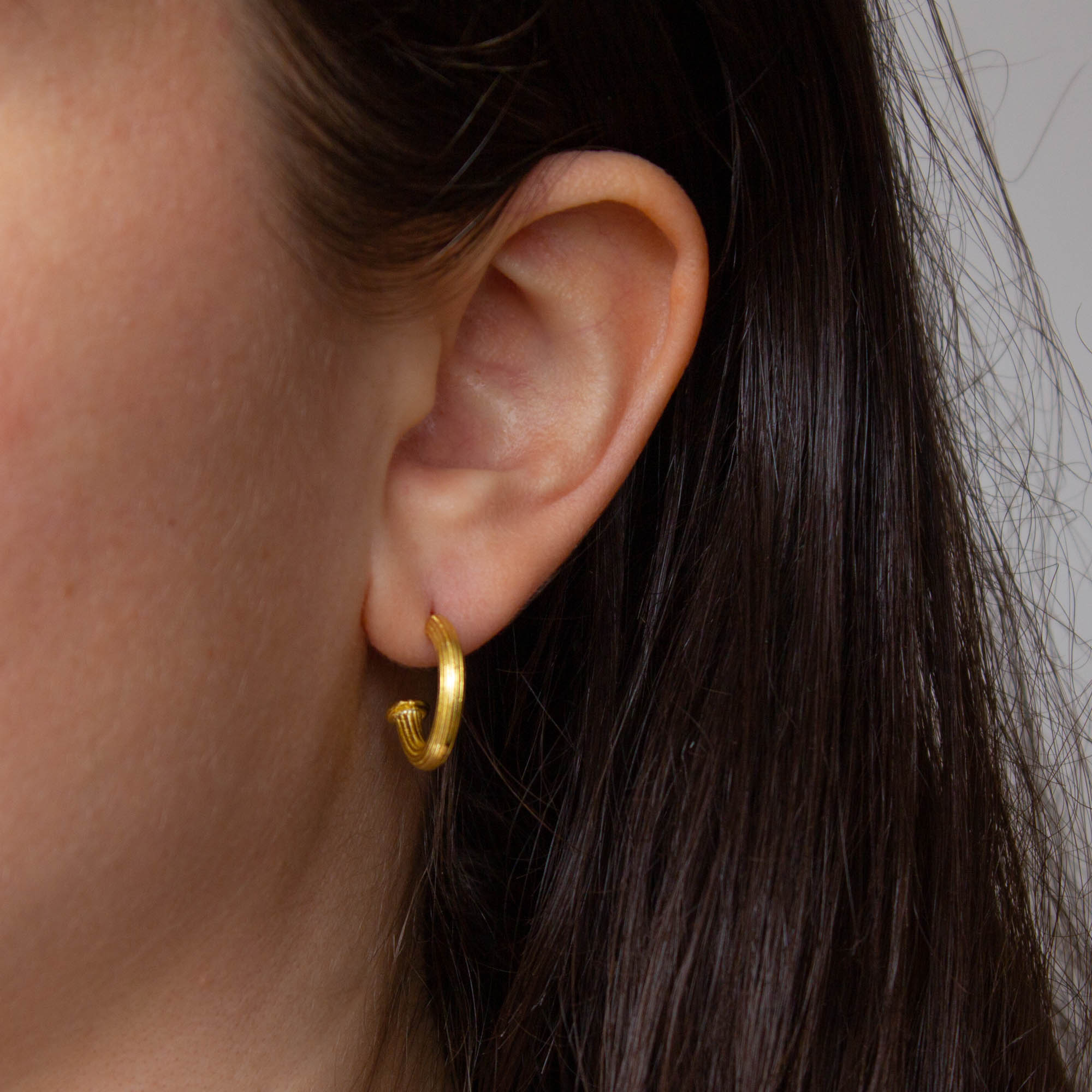 Model wearing 18k gold vermeil ridged textured half hoop earrings with stud fitting | Beyond Biasa
